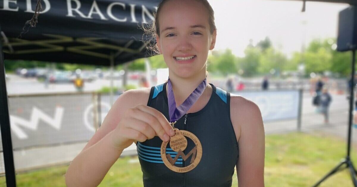 Lauren Harrison holds up her medal at the Victoria Youth Triathlon.