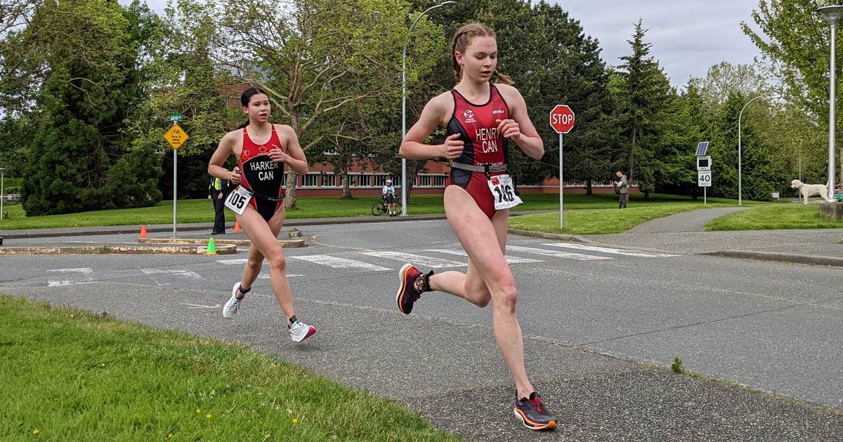 Two young women tear around the corner, to come running into the final laps of the Victoria Youth Triathlon 2022.