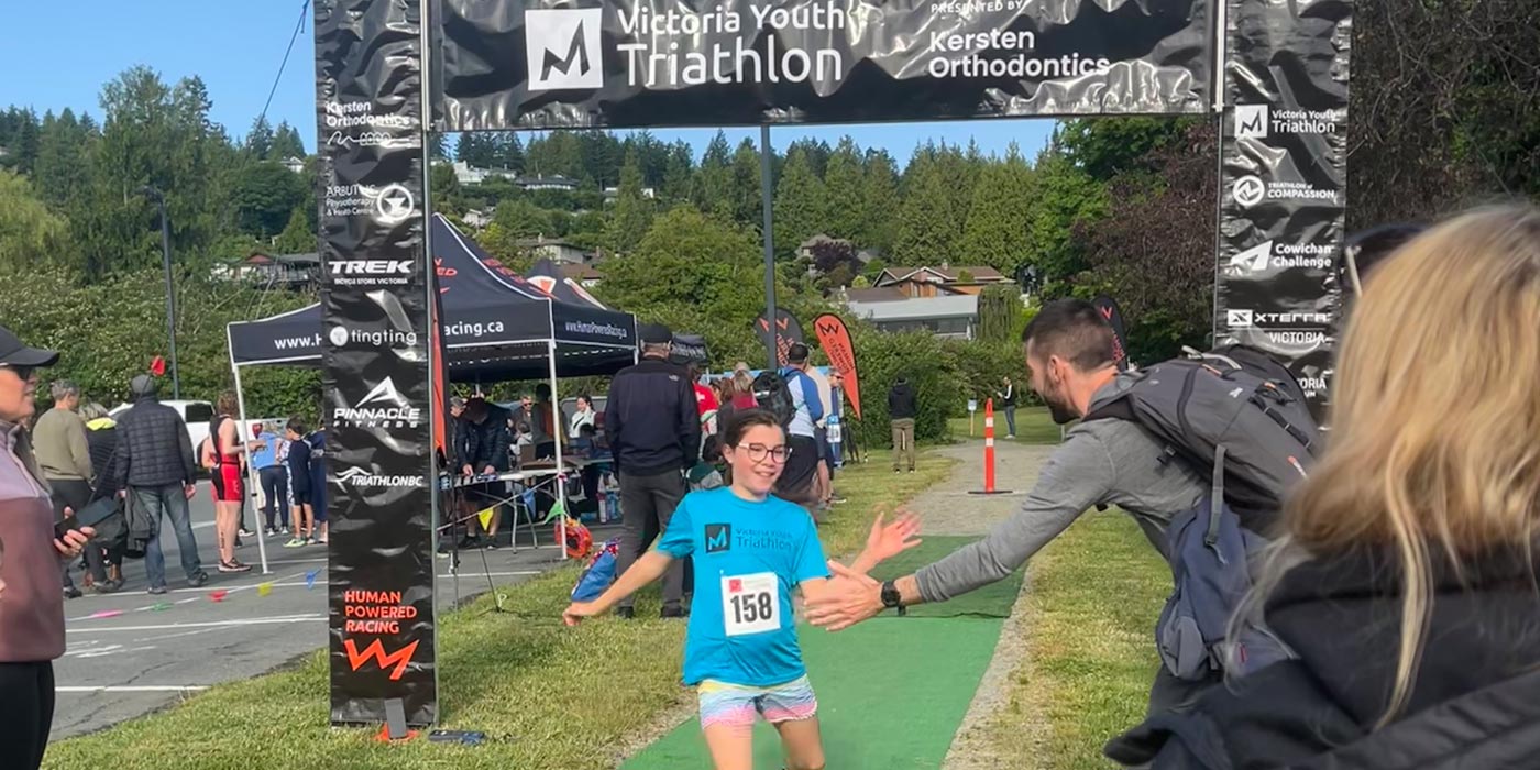 A racer crosses the finish line and gives a high five.